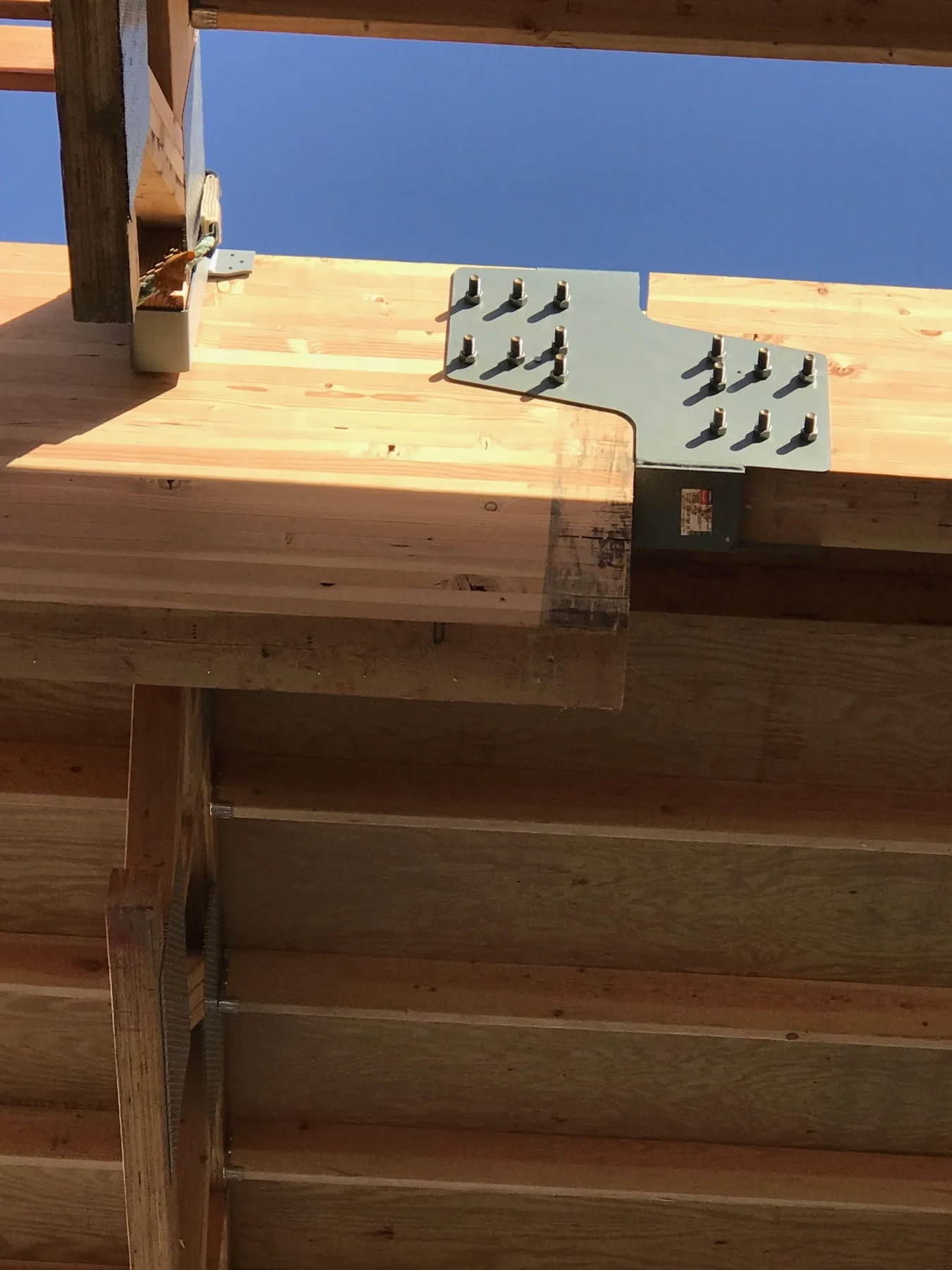 Bolted wood joists with metal hangers and diagonal bracing.